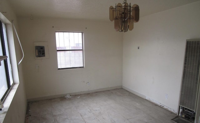 unfurnished room with an inviting chandelier and electric panel