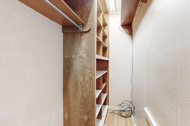 walk in closet with light hardwood / wood-style floors