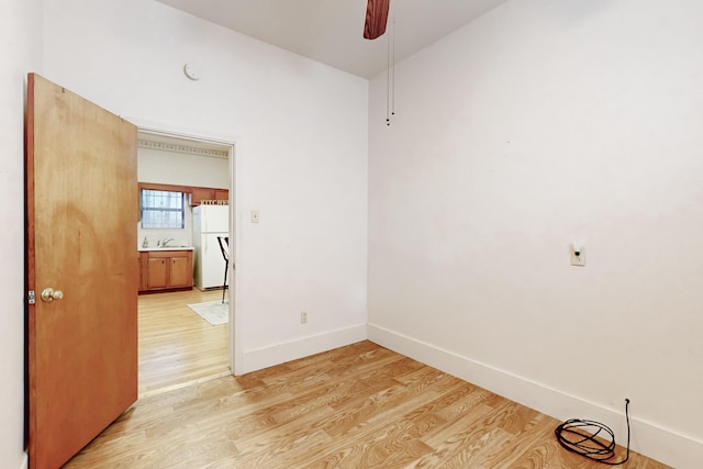 spare room featuring ceiling fan, sink, and light hardwood / wood-style flooring