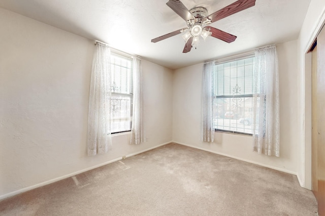 unfurnished room with ceiling fan and light colored carpet