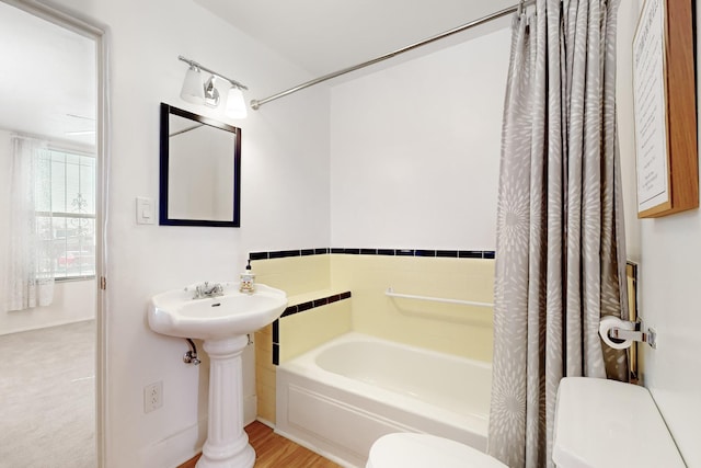 bathroom with toilet and shower / bath combination with curtain