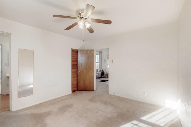 unfurnished room featuring ceiling fan and light colored carpet