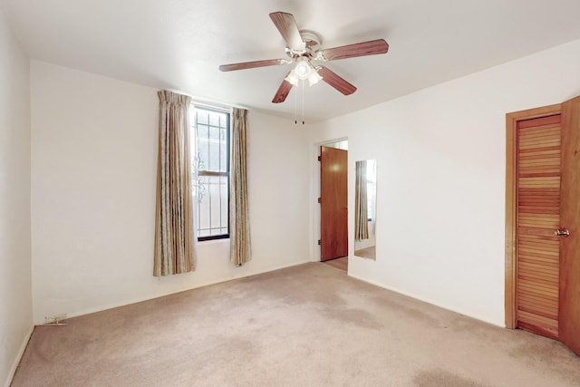 unfurnished room featuring ceiling fan and light carpet