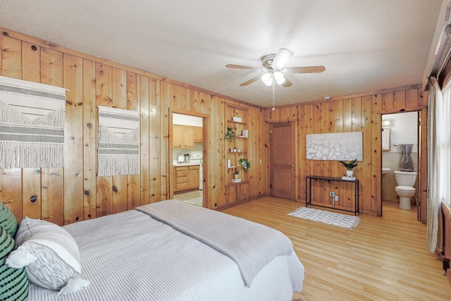 bedroom featuring ensuite bathroom, ceiling fan, and light wood-type flooring