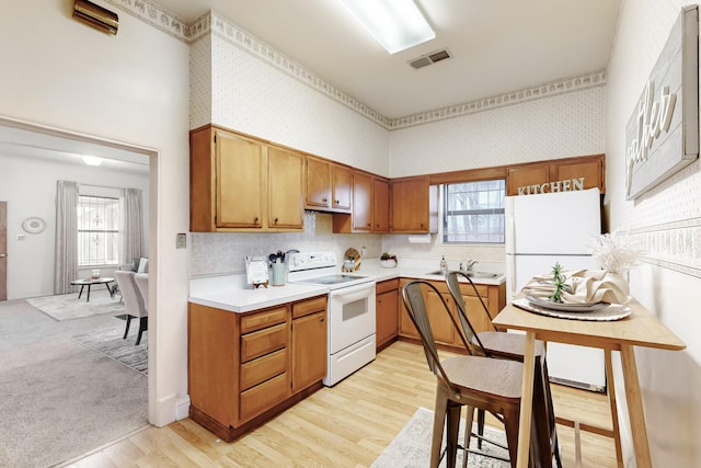 kitchen featuring sink, white electric range, and light wood-type flooring