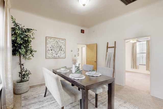 carpeted dining room with ceiling fan