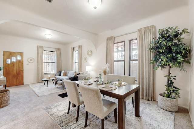 dining room featuring a healthy amount of sunlight and light colored carpet