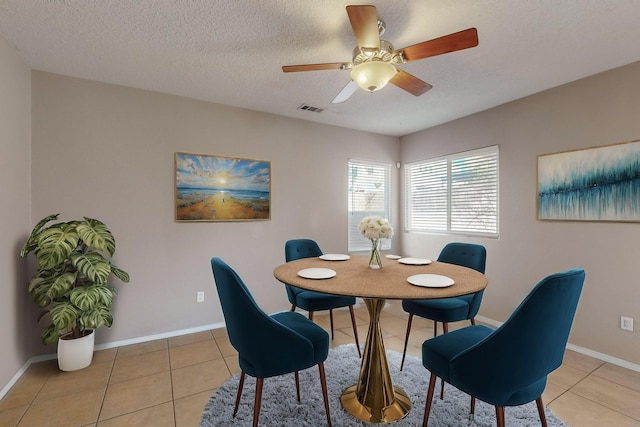 tiled dining area featuring ceiling fan and a textured ceiling