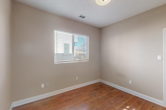 spare room with wood-type flooring and a textured ceiling