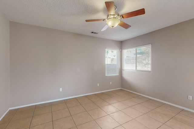 tiled spare room with ceiling fan and a textured ceiling