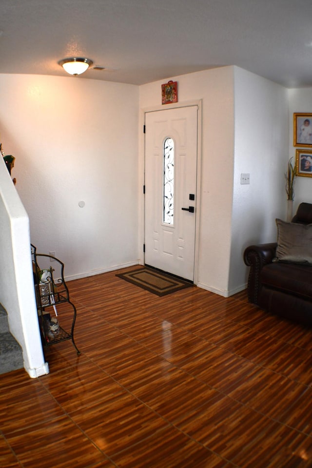 entrance foyer with stairs, baseboards, and wood finished floors