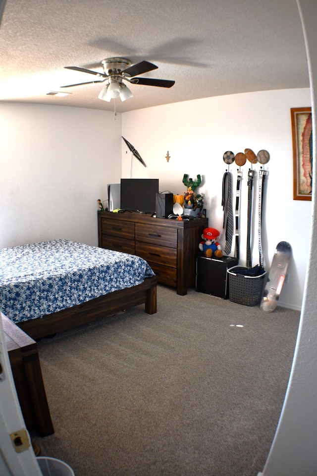 bedroom featuring a textured ceiling, carpet floors, and ceiling fan