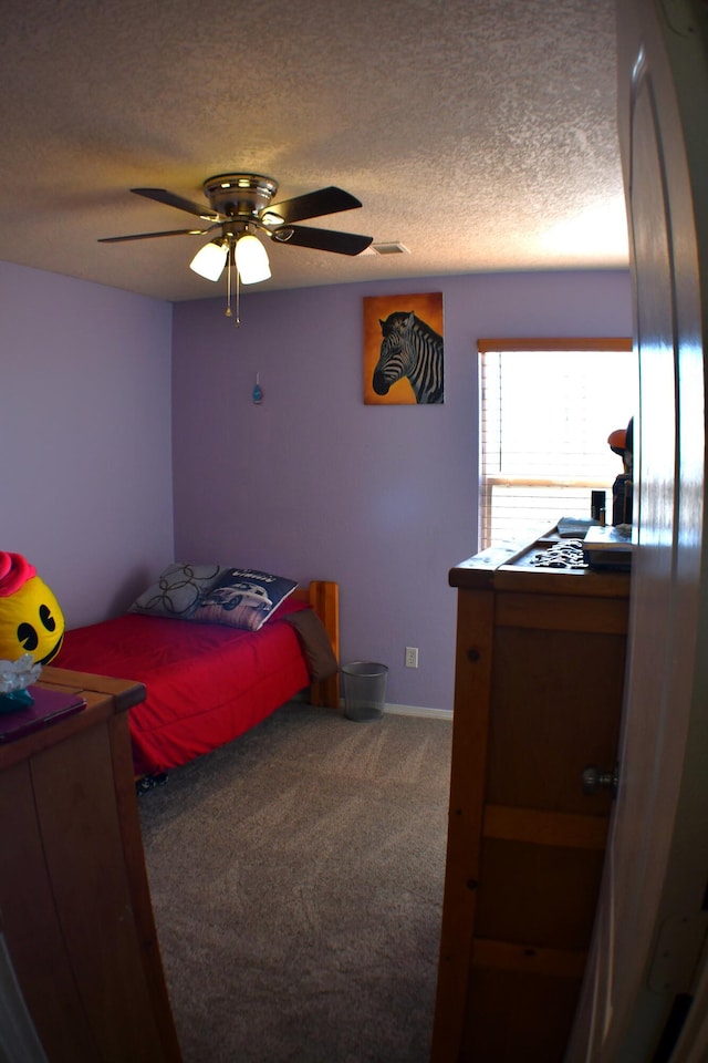 bedroom featuring a textured ceiling, carpet floors, ceiling fan, and stainless steel refrigerator