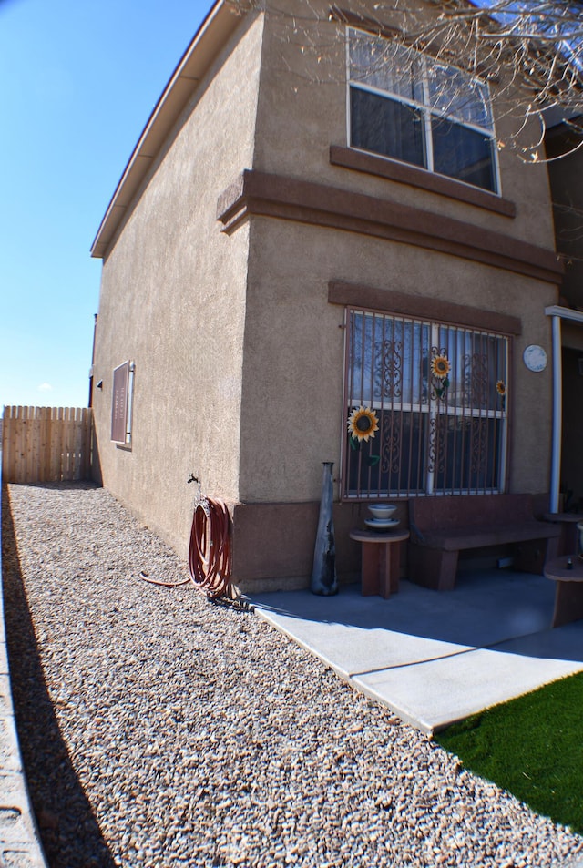 exterior space with mail area, fence, and stucco siding