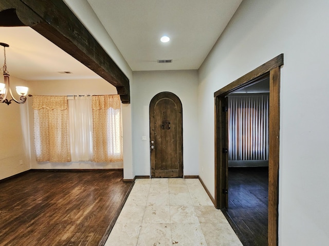 foyer entrance with an inviting chandelier and hardwood / wood-style floors