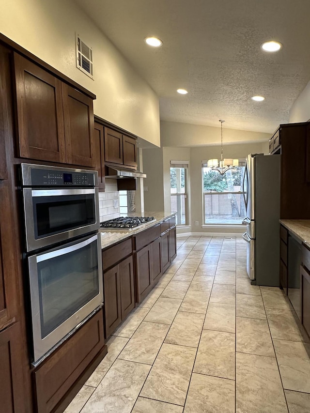 kitchen with visible vents, appliances with stainless steel finishes, dark brown cabinets, a chandelier, and vaulted ceiling