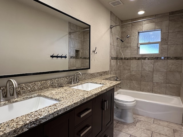 bathroom with toilet, tub / shower combination, visible vents, and a sink