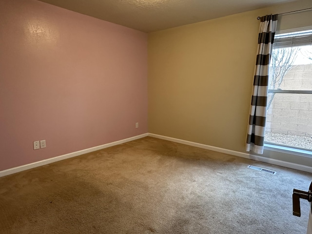 carpeted empty room with baseboards and visible vents