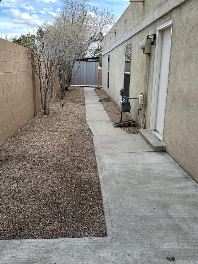 view of yard featuring an outbuilding, a fenced backyard, and a storage shed