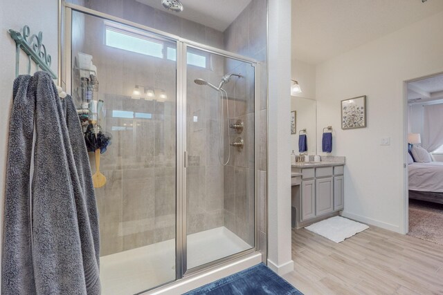 bathroom featuring toilet, wood-type flooring, an enclosed shower, and vanity