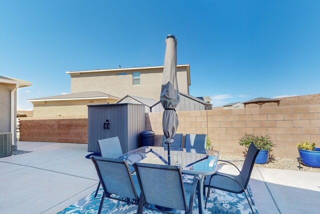 rear view of property featuring a storage unit and a patio