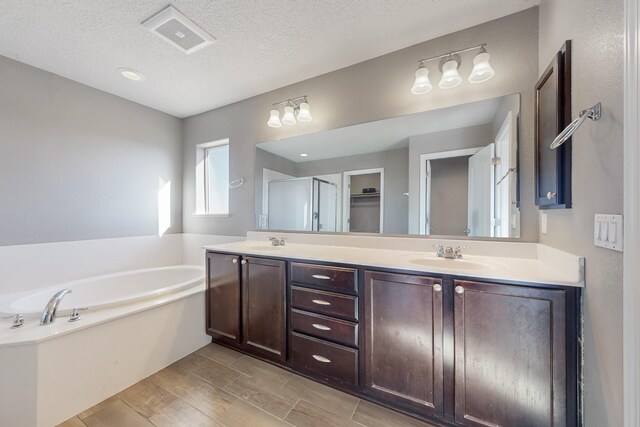 bathroom featuring vanity, a textured ceiling, and shower with separate bathtub