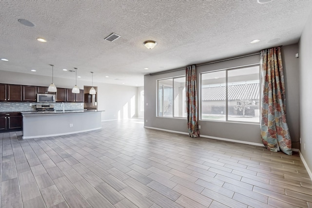 unfurnished living room with a textured ceiling and sink