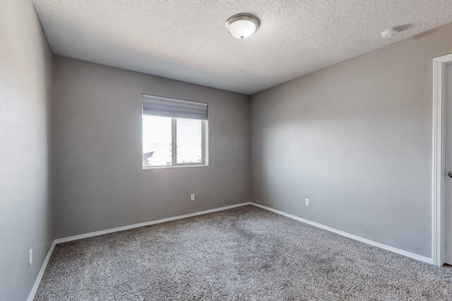 carpeted spare room featuring a textured ceiling