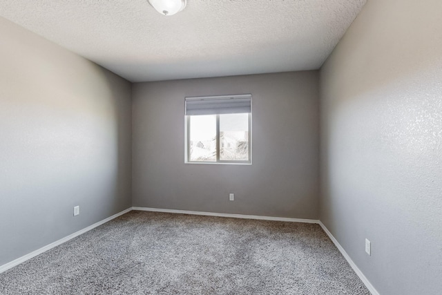 empty room with a textured ceiling and carpet flooring