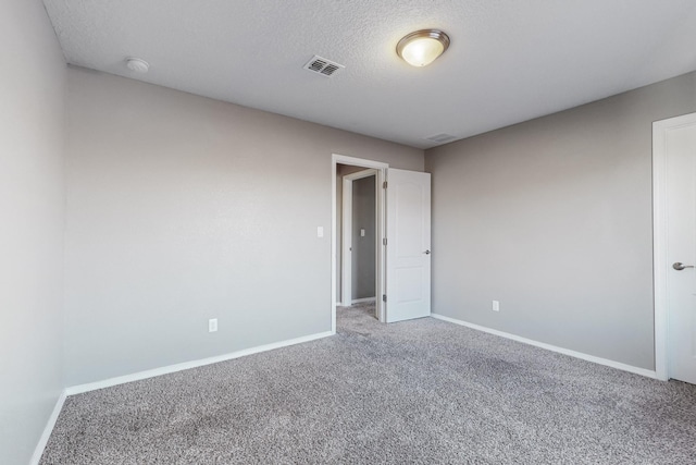 empty room featuring carpet and a textured ceiling