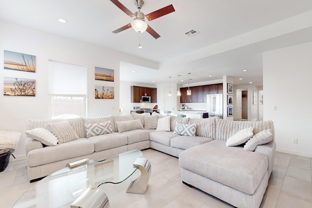 living room featuring light tile patterned floors and ceiling fan