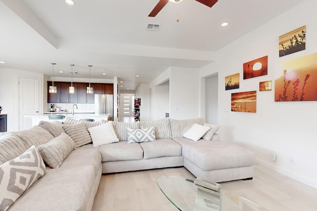 living room featuring ceiling fan and sink