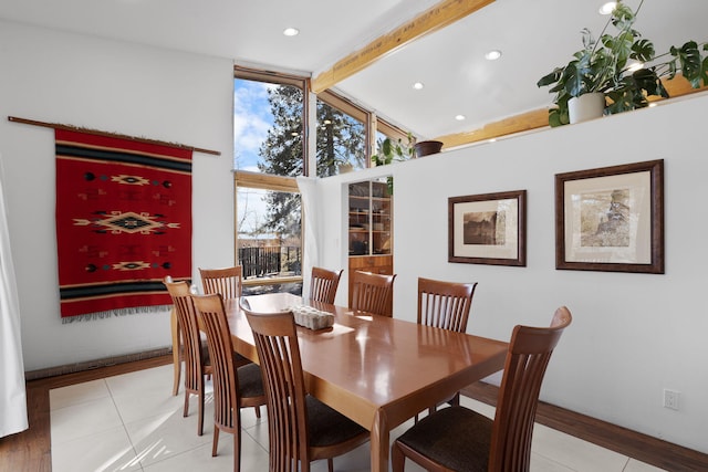 tiled dining room featuring high vaulted ceiling and beam ceiling