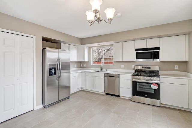 kitchen with sink, appliances with stainless steel finishes, a notable chandelier, pendant lighting, and white cabinets