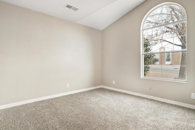 carpeted spare room featuring lofted ceiling