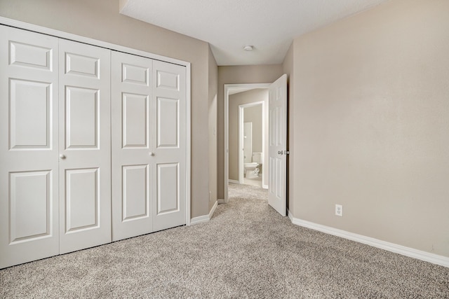 unfurnished bedroom with light colored carpet and a closet