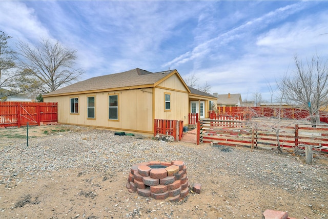 back of house with a fire pit