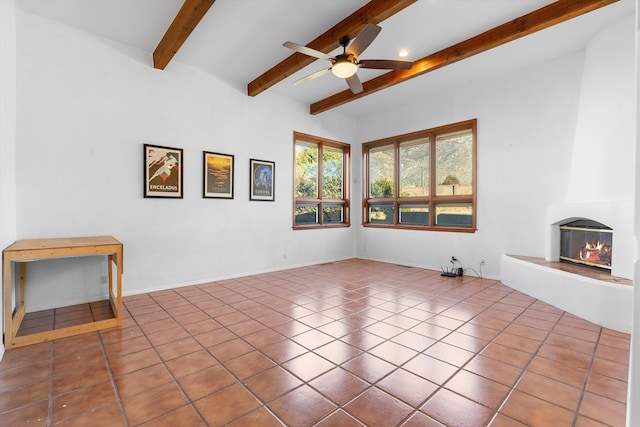 unfurnished living room featuring ceiling fan, tile patterned floors, beamed ceiling, and a fireplace