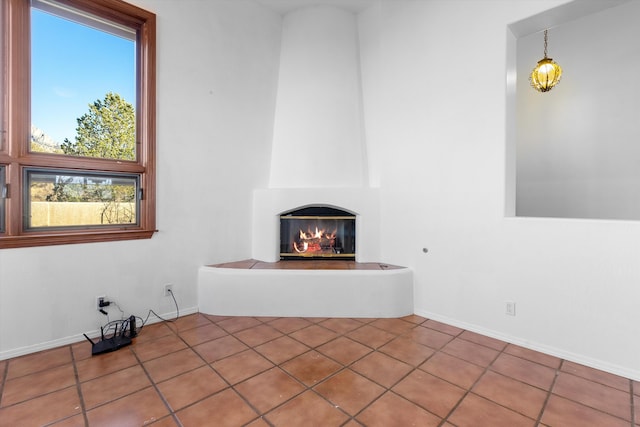 unfurnished living room featuring a large fireplace and tile patterned flooring