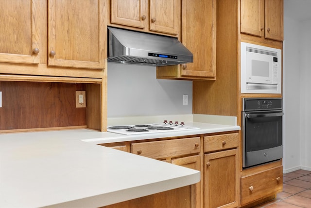 kitchen featuring light tile patterned floors, extractor fan, and white appliances