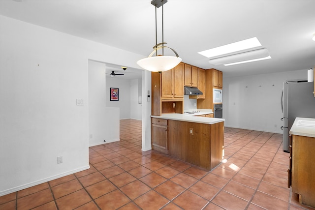 kitchen featuring pendant lighting, white microwave, stainless steel fridge, kitchen peninsula, and ceiling fan