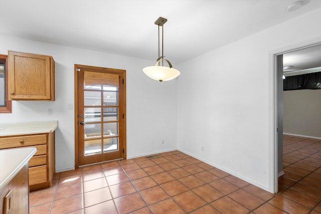 unfurnished dining area with ceiling fan and light tile patterned flooring