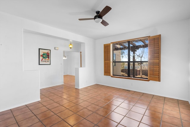 spare room featuring ceiling fan and tile patterned flooring