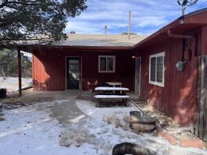 view of snow covered rear of property