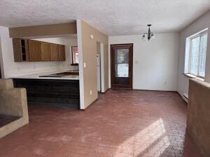 kitchen featuring a textured ceiling, a baseboard heating unit, and a chandelier