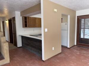 kitchen featuring white fridge and a textured ceiling