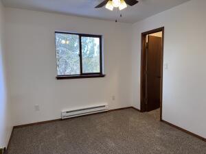 carpeted empty room featuring ceiling fan and a baseboard radiator