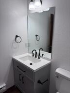 bathroom with toilet, vanity, and baseboard heating