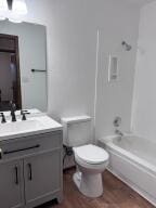 full bathroom with shower / bath combination, toilet, vanity, and hardwood / wood-style floors