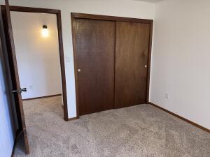 unfurnished bedroom featuring a closet and light colored carpet